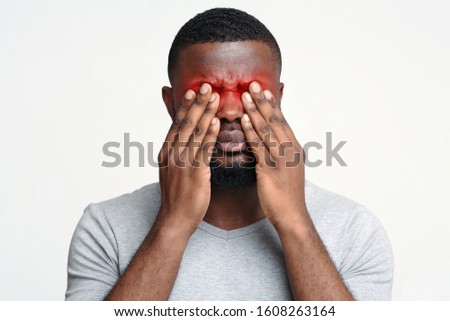 Overworked afro man rubbing eyes, suffering from eye pain Royalty-Free Stock Photo #1608263164