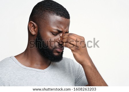 Tired afro man touching his nose bridge, suffering from eye pain, tired eyes, copy space Royalty-Free Stock Photo #1608263203