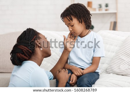 Consoling And Care. Afro mother supporting her upset daughter, apologizing, caressing offended child Royalty-Free Stock Photo #1608268789