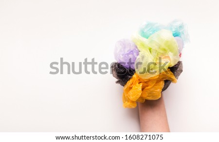 Zero waste lifestyle concept. Hand with colored plastic bags isolated on white background, panorama, copy space