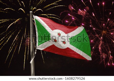 Burundi flag blowing in the wind at night with fireworks