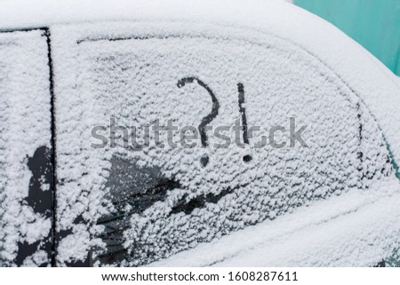 Snow covered car with question and exclamation mark on window, concept
