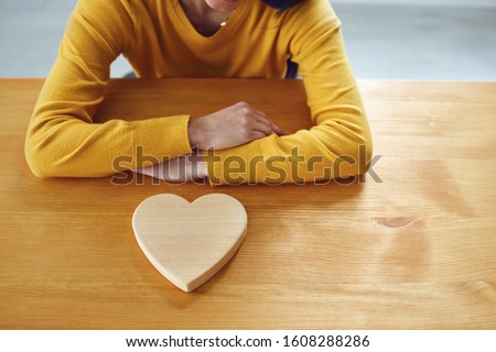 Valentine's day. Girl with a wooden heart on the table