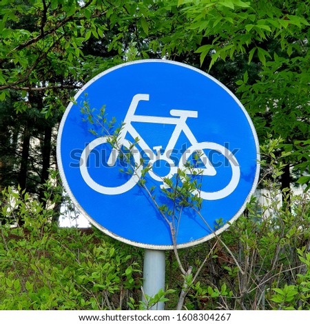 A road sign of bike route surrounded by forest