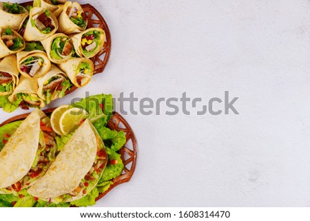 Delicious soft flour tortillas with salad and meat. Mexican cuisine.