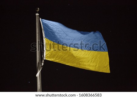 Ukraine flag blowing in the wind at night