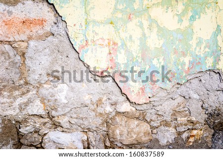 Textured wall that is crumbling tinted in yellow and light green