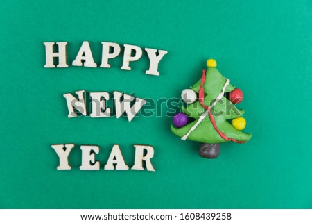 Happy new year and Merry Christmas card minimalistic concept. Handmade plasticine tree cutting design. Applique paper red and green cutout
