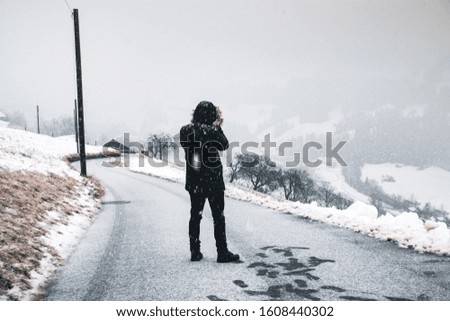 A Man Taking A Picture Of The Road With Snow.