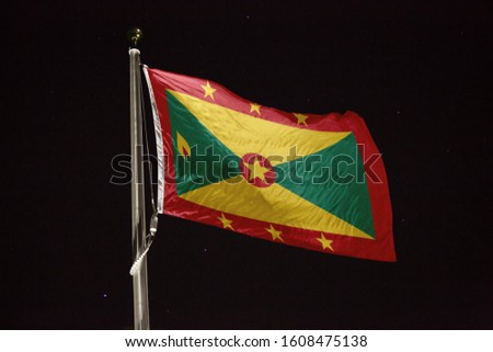 Grenada flag blowing in the wind at night