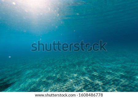 underwater shot of sand sea bottom with sun beams