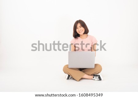 Cute Asian teen woman is working with computer on white background 