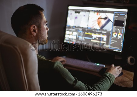 Video montager mounts video at desktop. Home workstation. Royalty-Free Stock Photo #1608496273