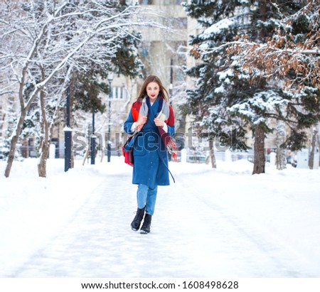 Full-length portrait of young girl walking in a winter park