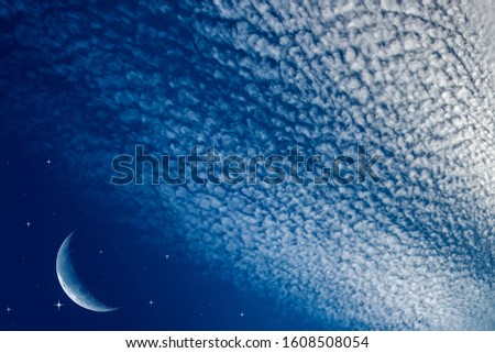 Starry sky with half moon in scenic cloudscape . 