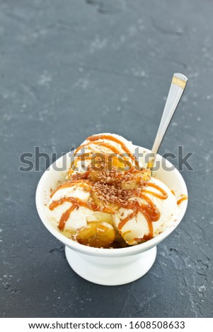 vanilla ice cream with bananas and caramel in a bowl. Royalty-Free Stock Photo #1608508633