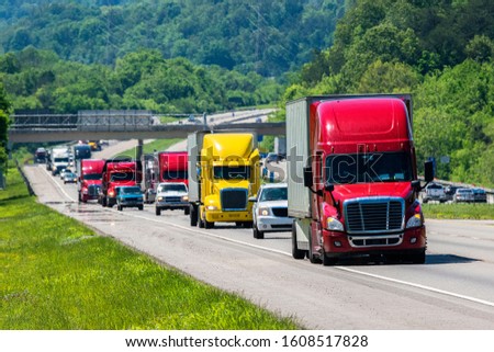 Horizontal shot of a red semi leading the traffic on an interstate highway. Royalty-Free Stock Photo #1608517828