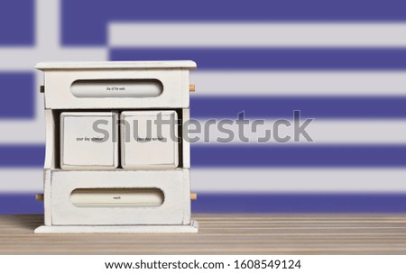 Wooden retro calendar with free space for a date on the background of the flag of Greece. Template for writing the dates of the national holidays of Greece with free text space