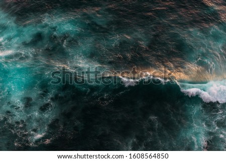 Sea wave at sunset. Sea wave from above. Seascape from the top. Aerial wave background. Drone shot directly from above, green turquoise color, huge waves. Ocean as a background from a bird's eye view