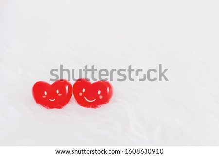 Couple red heart with a smiling face on soft white wool table background.Concept of love in the lovers of the festival of valentine day.