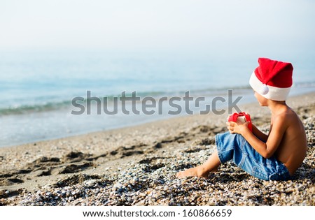 Boy is waiting for a Christmas sitting on the beach
