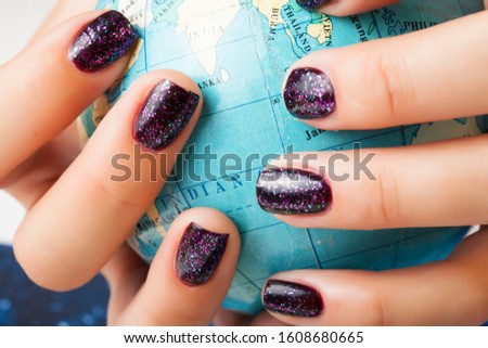 woman hands with purple manicure holding Earth ball, global planet issues concept