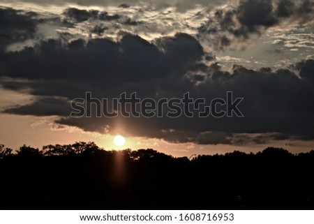 A forest silhouette under a cloudy sky during a beautiful sunset - a cool picture for backgrounds