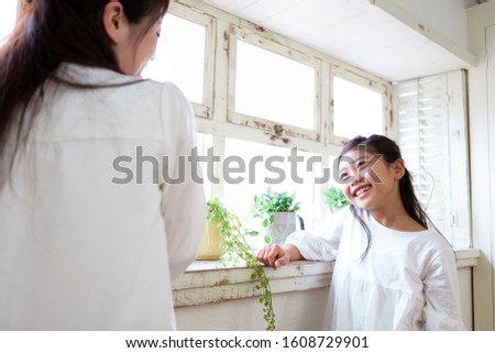 Mother and daughter watering plants