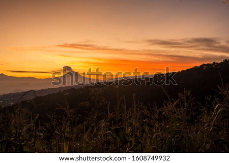 mountains and volcano with red sunrise