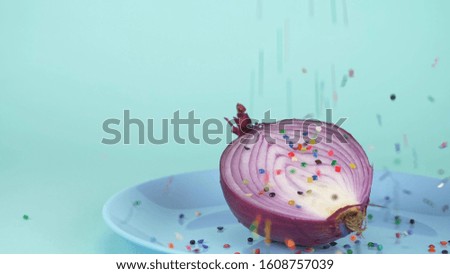 Fashionable food design. half of the onion is sprinkled with multi-colored confectionery sugar sprinkles.