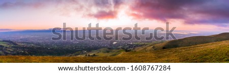Panoramic sunset view of San Jose and South San Francisco Bay Area, also known as Silicon Valley; hills starting to turn green visible in the foreground; California