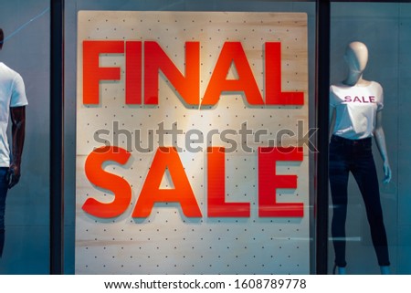 Storefronts with sale sign behind the glass window in shopping mall