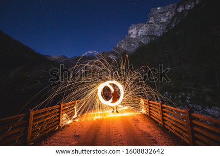 time-lapse photography of person holding steel wool on bridg