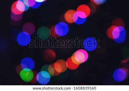 Defocused blurry bokeh image from multi-colored light bulbs in the dark.
