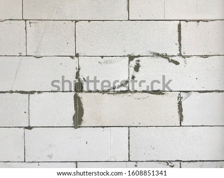 autoclaved aerated concrete (aac), lightweight concrete brick texture background during work in process of cement plastering at construction side, raw material for home building, house wall