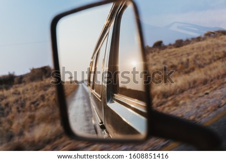 look back into the side mirror of a van car
