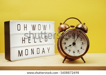 Hello Monday text in lightbox with alarm clock on Yellow background