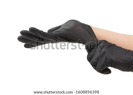 Woman puts on black rubber gloves. Isolated on white.