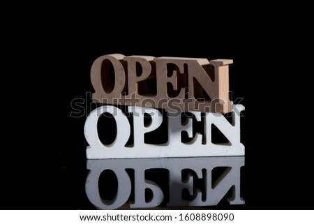 "Open" sign board for business. Black background. use of signs  to communicate a message.