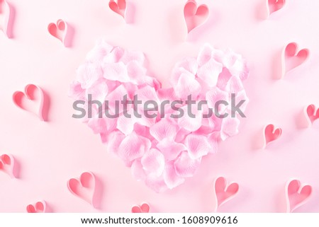 Small Pink paper hearts in shape of heart on Light pink pastel paper background. Love and Valentine's day concept.