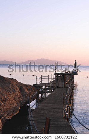 Pier at sunrise. Beautiful picture. Wooden pier on the background of the sea and islands.