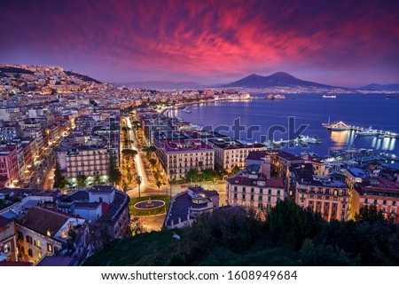 Naples, twilight evening pink violet sunset. Town Napoli in Italy, travelling in the Europe. Urban landscape with city, sea, hills and Vesuvio Volcano. Beautiful sunset sky, end of the day. Royalty-Free Stock Photo #1608949684