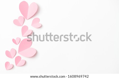 Paper elements in shape of heart flying on white paper background. Love and Valentine's day concept. Birthday greeting card design.