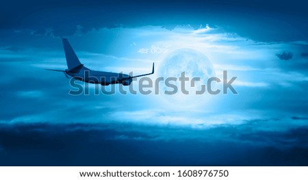 Passenger airplane in the sky against full moon "Elements of this image furnished by NASA "