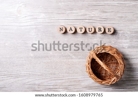 Word nature made from wooden letters over gray wooden background. Top view, flat lay. Copy space