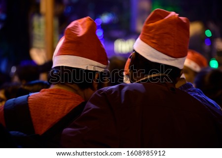 Boys are celebrating Christmas eve in night wearing Christmas cap on street at Kolkata.