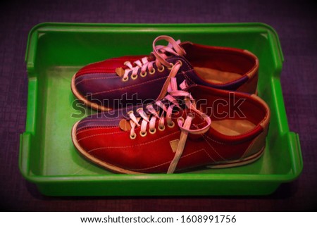 Multicolored leather shoes with laces, a pair, for playing bowling in a plastic tray