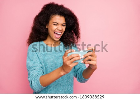 Turned photo of cheerful crazy mad woman rejoicing in completing level in video game shouting isolated pink pastel color background