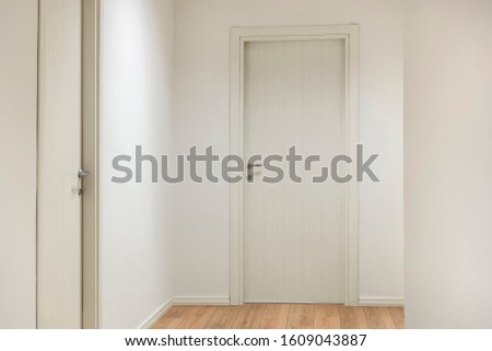 Office entrance with white wooden doors and wood flooring