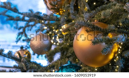 Golden bauble hanging from a Christmas tree.